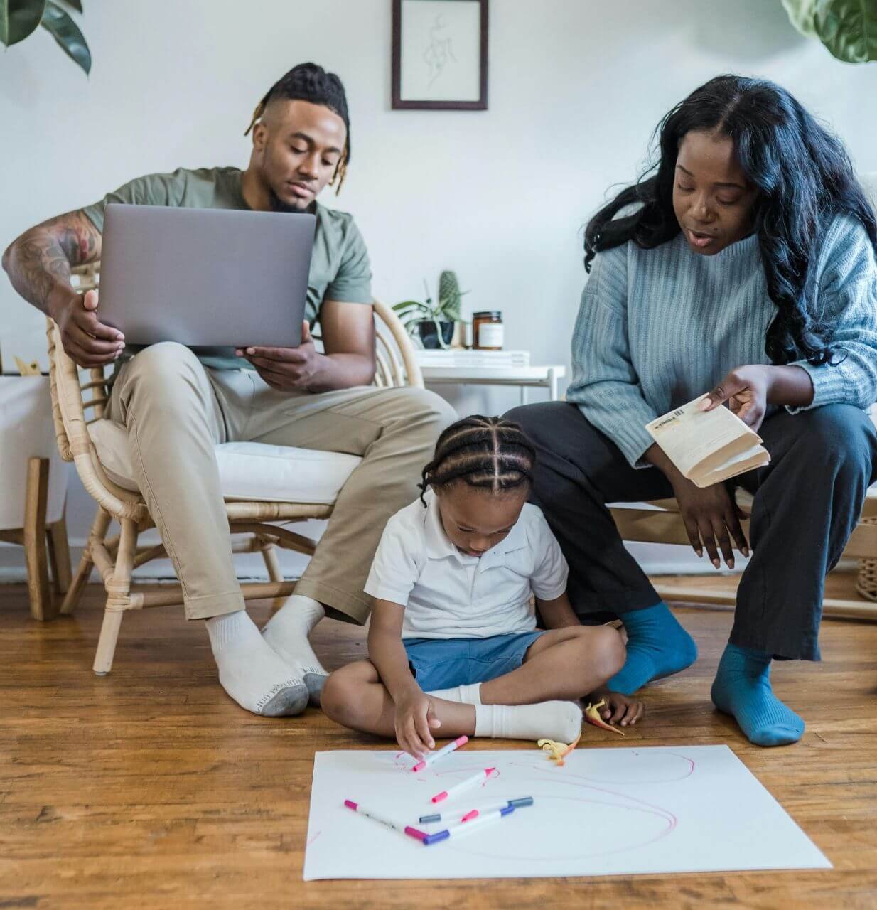 petite fille dessinant pendant que ses parents la regardent