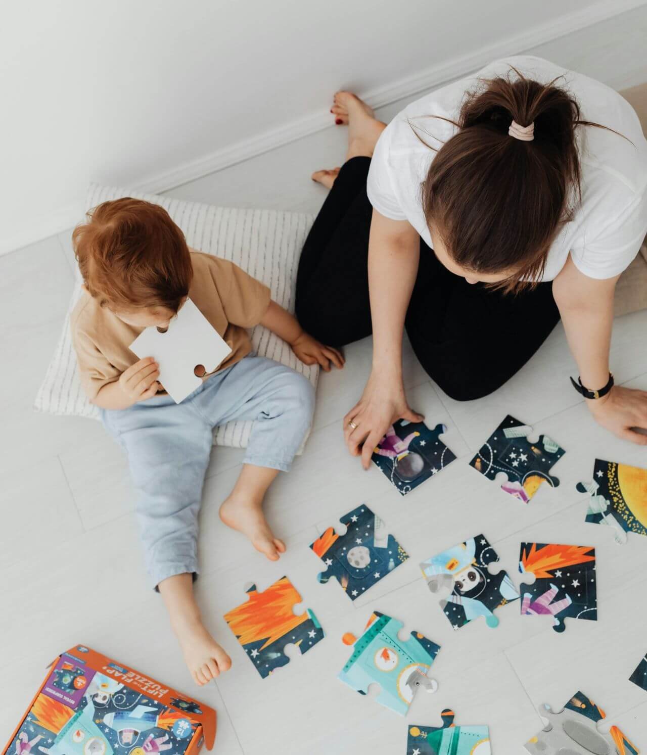 enfant faisant un jeu assis avec sa mère dans une chambre d'hôtel