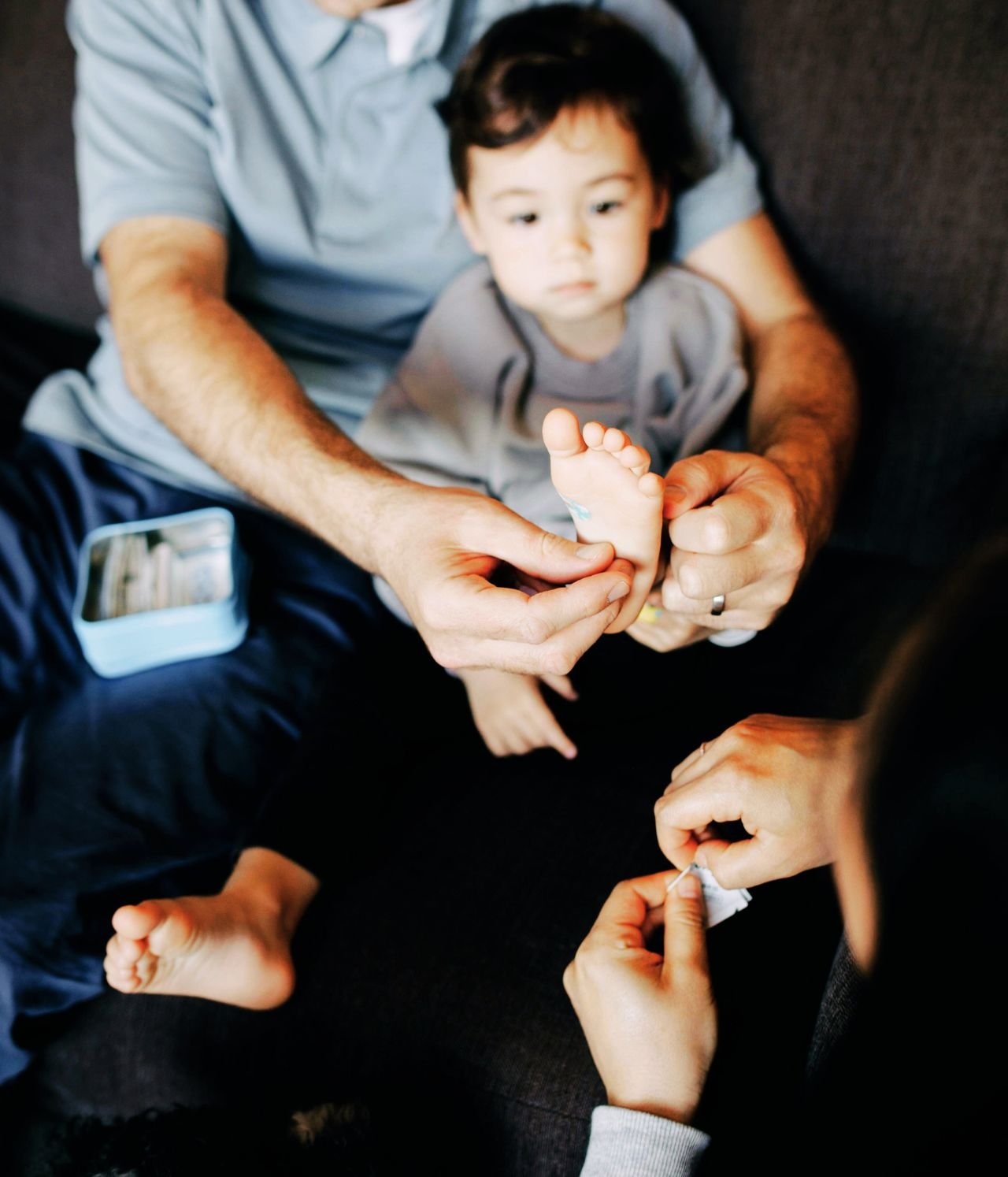 parents soignant le pieds d'un jeune enfant en voyage