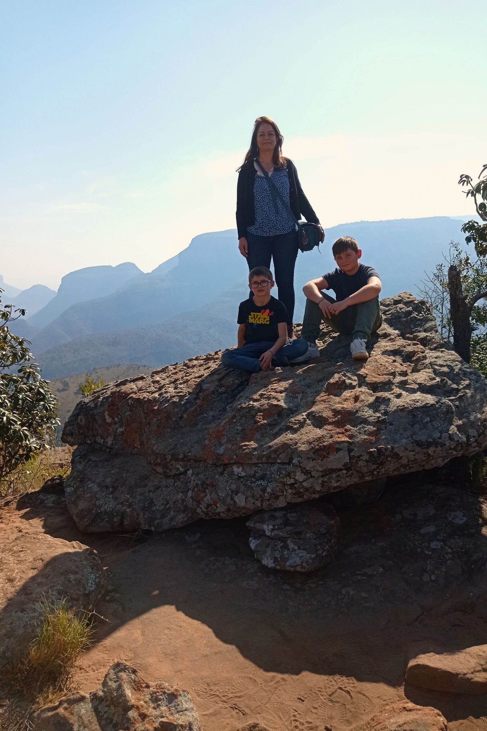 Julie, la fondatrice avec ses enfants devant un paysage de canyon en Afrique